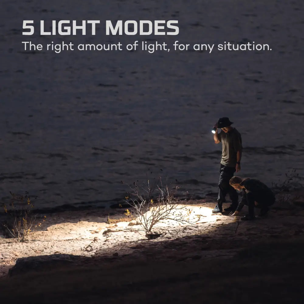 A sleek modern 12k flashlight emitting a bright beam of light in an outdoor setting