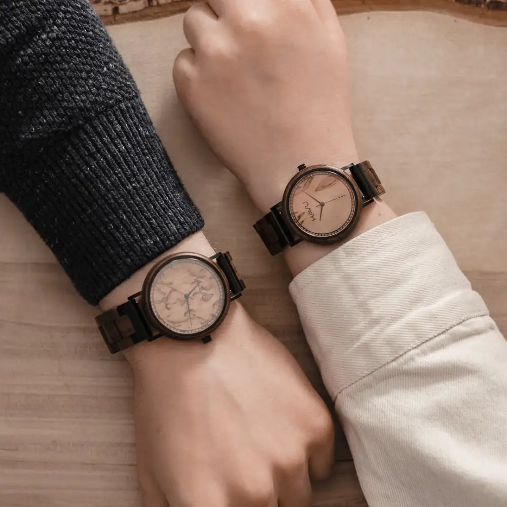 Two matching aava 38mm wooden watches with dark brown frames and straps and light-colored map patterned faces