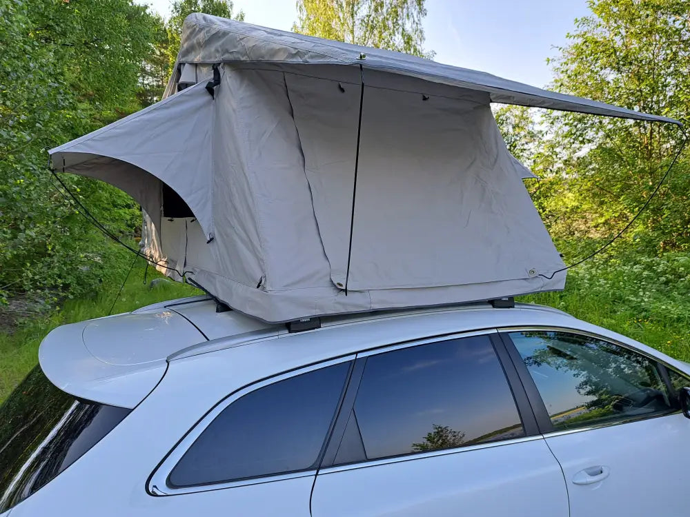 Auton kattoteltta ilma pitkä 1.4 harmaa asennettuna valkoisen auton katolle, tyylikäs ja kompakti kangasrunko