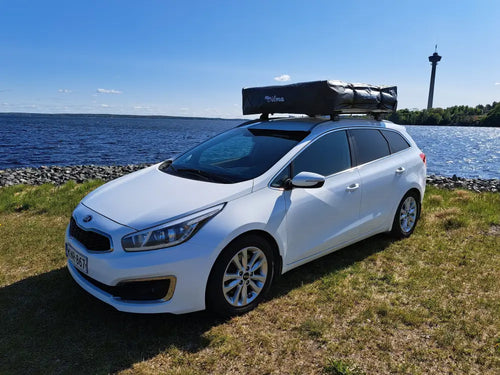 Valkoinen kia ceed farmariauto mustalla kattolaatikolla auton kattoteltta ilma pitkä 1.6 harmaa takakuvassa