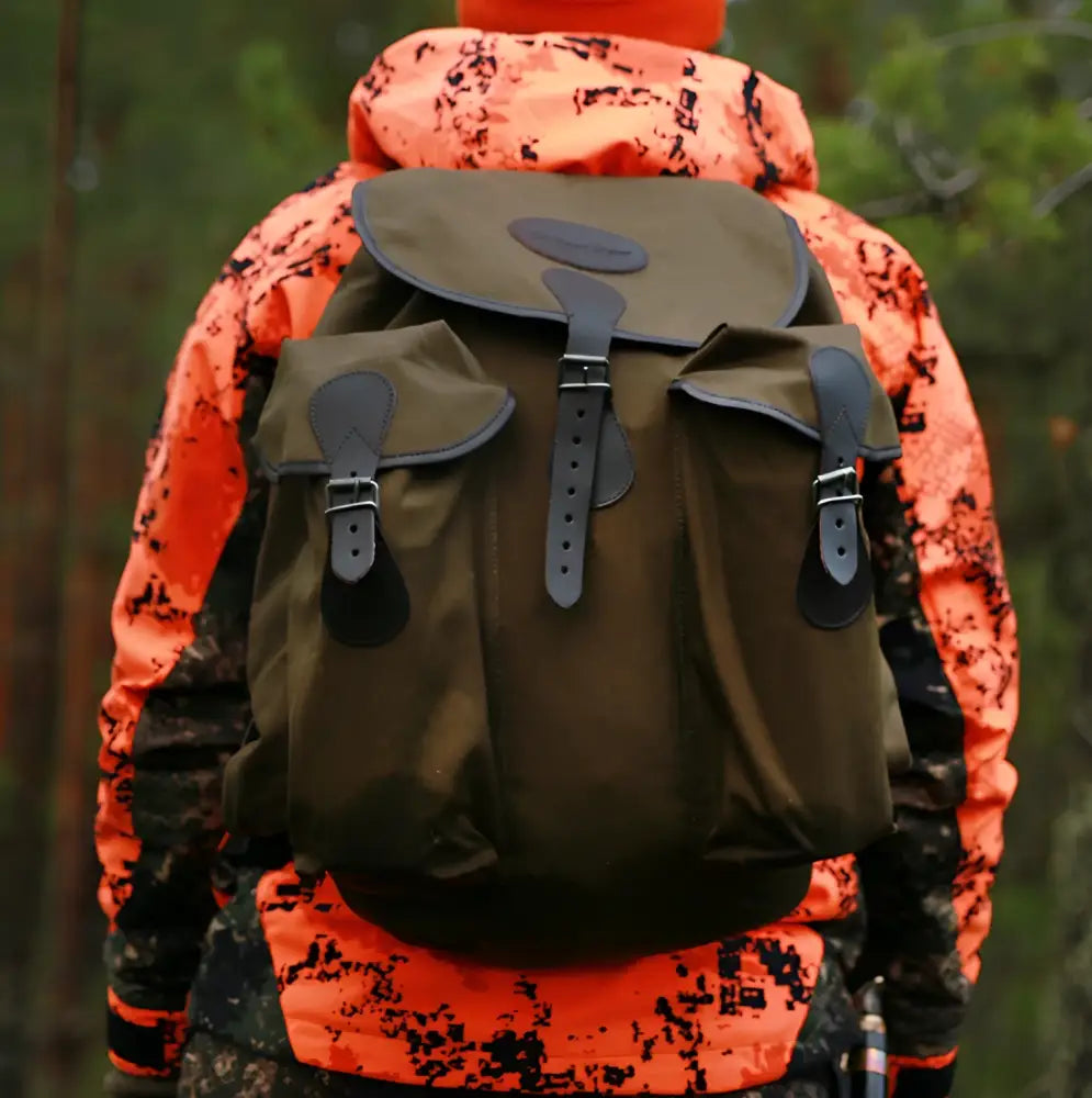 Olive green canvas hunting pack with black leather straps and buckles bear claw jätkän reppu product image