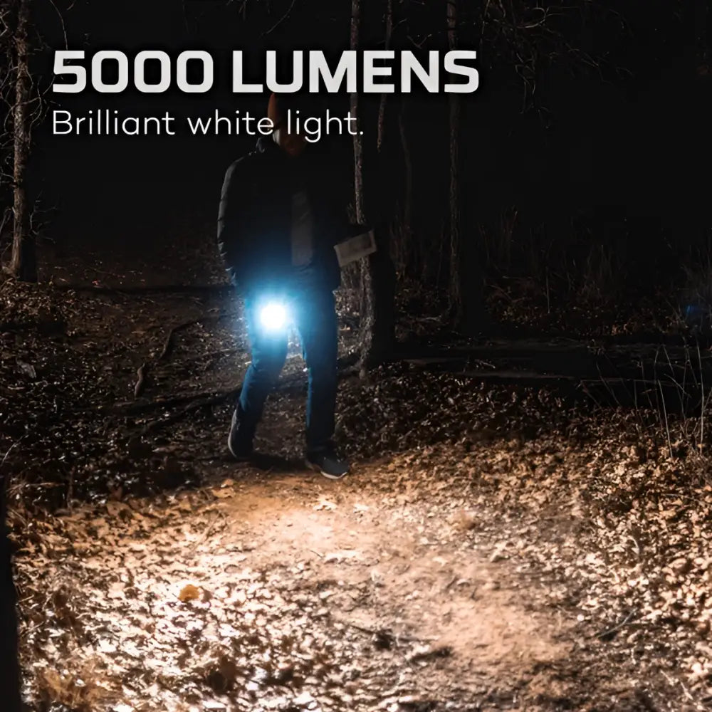 Davinci 5000 kirkas valkoinen 5000 lumenin taskulamppu kiinnitettynä vyötärölle valaisemaan metsänpohjaa