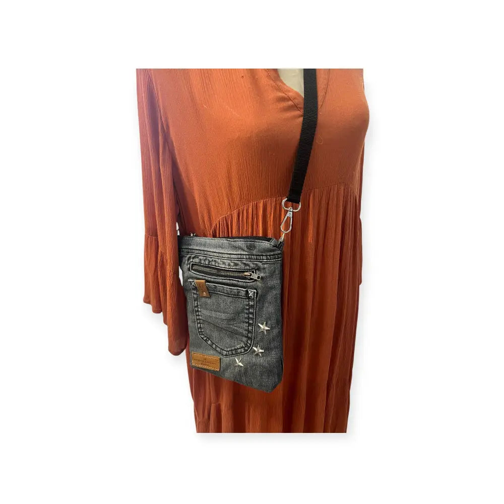 Farkkukassi kira on farkkumateriaalinen crossbody-laukku hopeisilla tähtikirjailuilla ja ruskealla nahkalaikulla