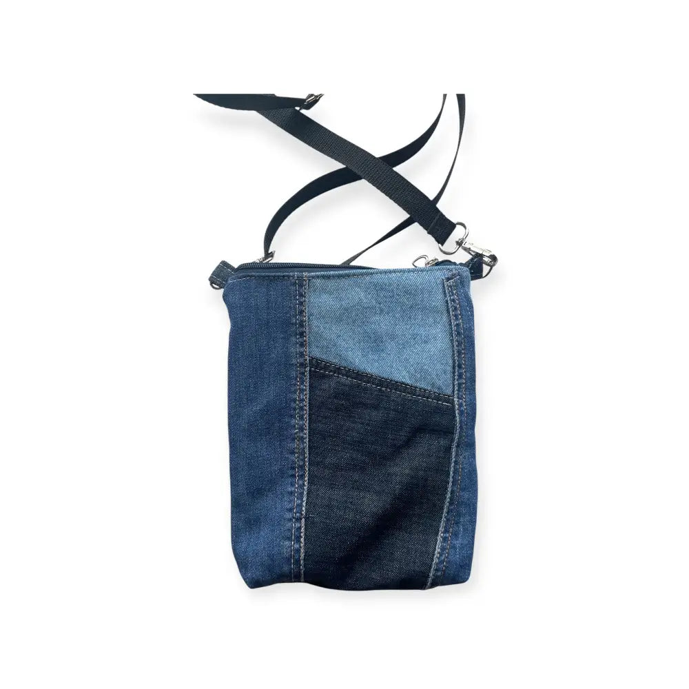 Farkkukassi Kira on sinisen sävyinen kirjova denim-laukku säädettävällä mustalla olkahihnalla ja hopeisilla yksityiskohdilla
