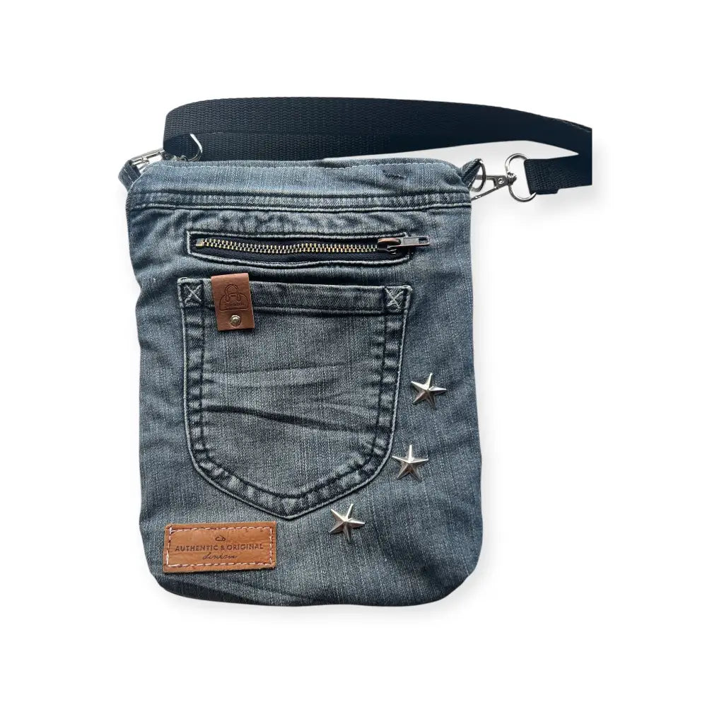 Denim crossbody bag farkkukassi kira with silver star studs and brown leather patches in front view