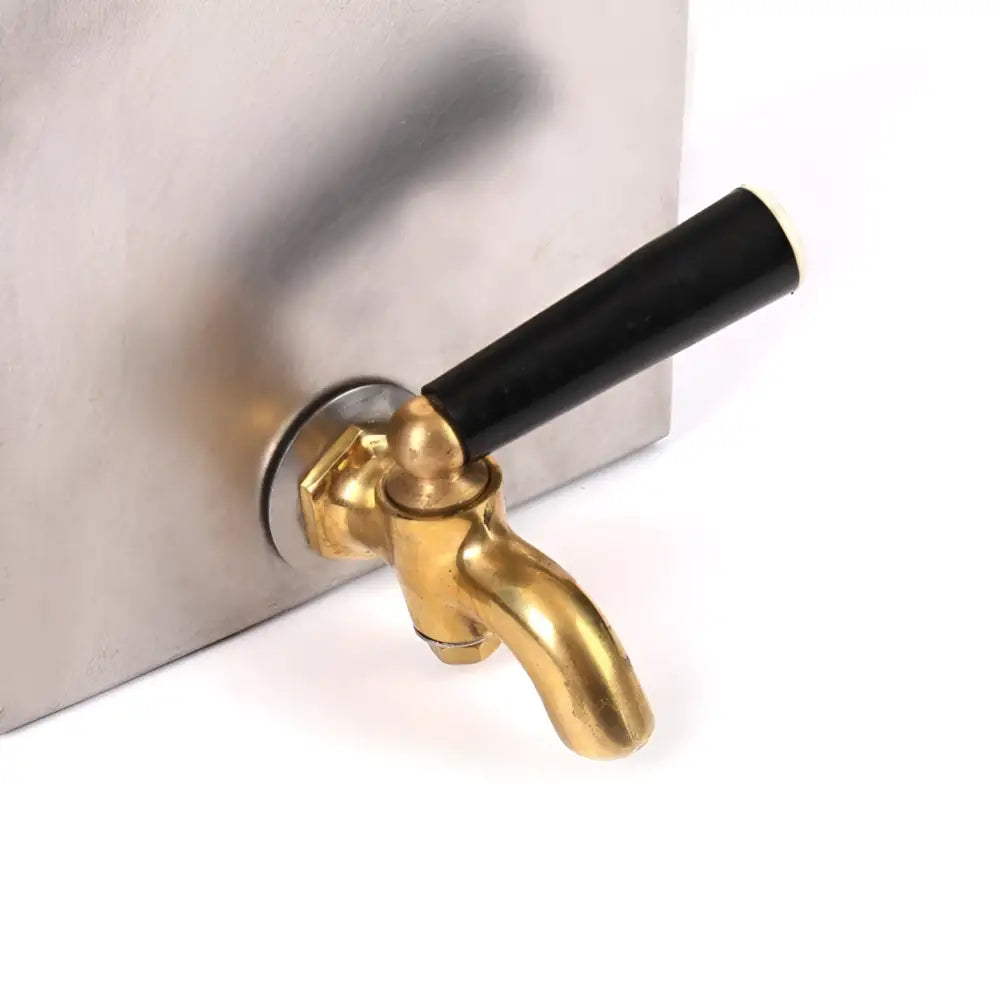 Gold-colored brass tap with black handle mounted on stainless steel 2l Haghus Bunker lämminvesivaraaja kaminaan container