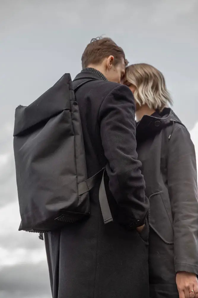 Musta minimalistinen hölär säänkestävä reppu kestävästä kankaasta ja modernilla tyylillä