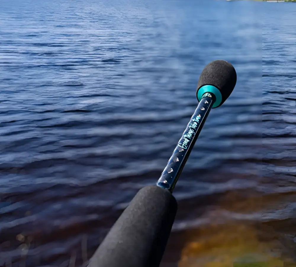 Black fishing rod kalastajan kanava tirri micro 183cm with teal accents and textured grip with handwritten text on shaft