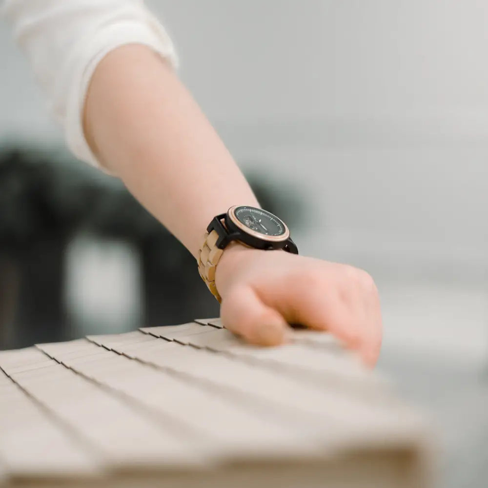 A elegant korpi 40mm wooden watch with a black face and gold-toned two-tone design