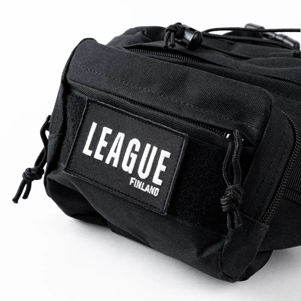 Black tactical-tyylinen vyölaukku jossa edessä näkyvä valkoinen league finland -logo leaguen batch vyölaukku