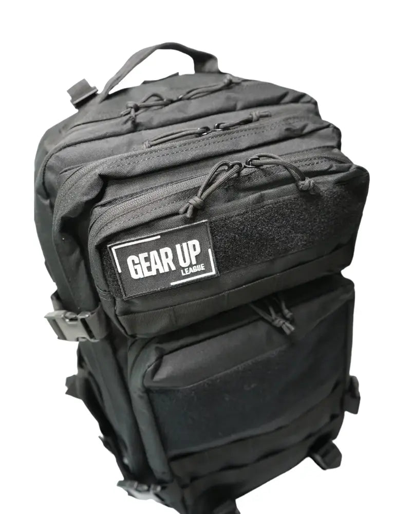 Musta tactical reppu 45l useilla vetoketjutaskuilla ja gear up league -merkillä edessä urheilukäyttöön