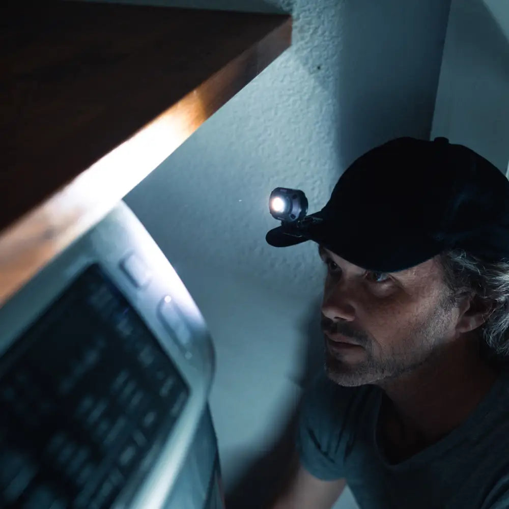 Musta ladattava mycro 250 otsa- ja lippavalaisin kirkkaalla valkoisella valolla kiinnitettynä lippikseen