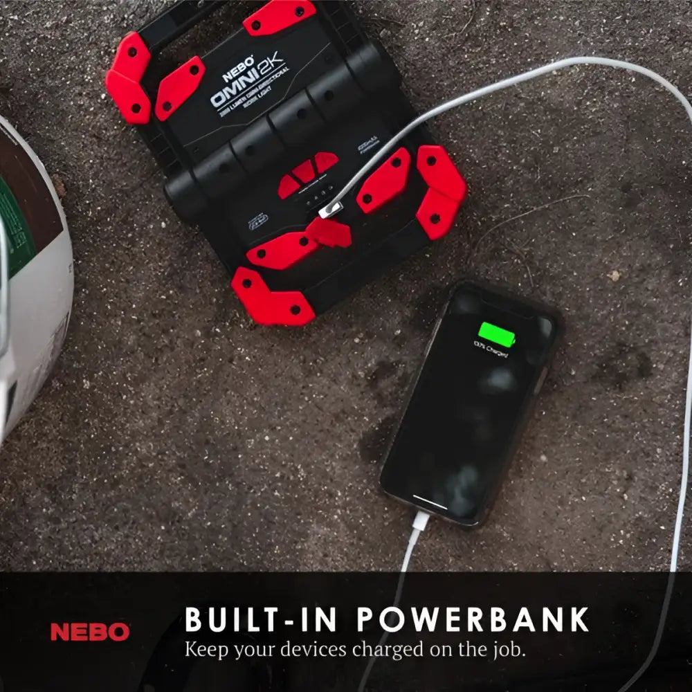 Black and red nebo omni 2k worklight portable power bank with rugged handle-like grips for durability
