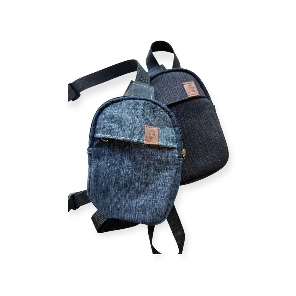 Denim-mallinen pikkureppu mustilla hihnoilla ja ruskeilla nahkapaloilla, selkäpuoli näkyvissä
