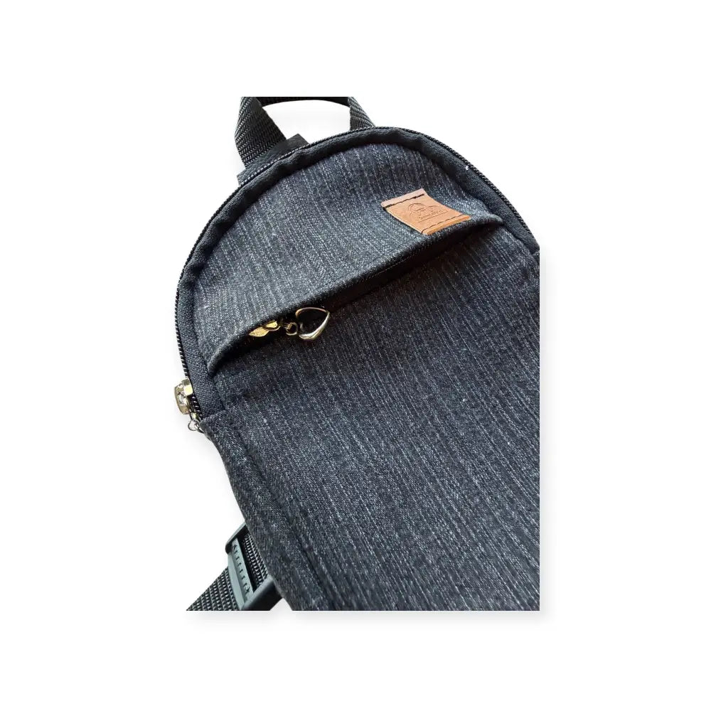 Dark blue denim-textured pikkureppu farkku crossbody bag with brown leather patch and gold-tone zipper hardware