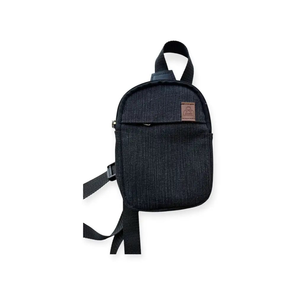 Pikkureppu farkku musta farkkukankainen crossbody-laukku, jossa edessä ruskea nahkainen merkki