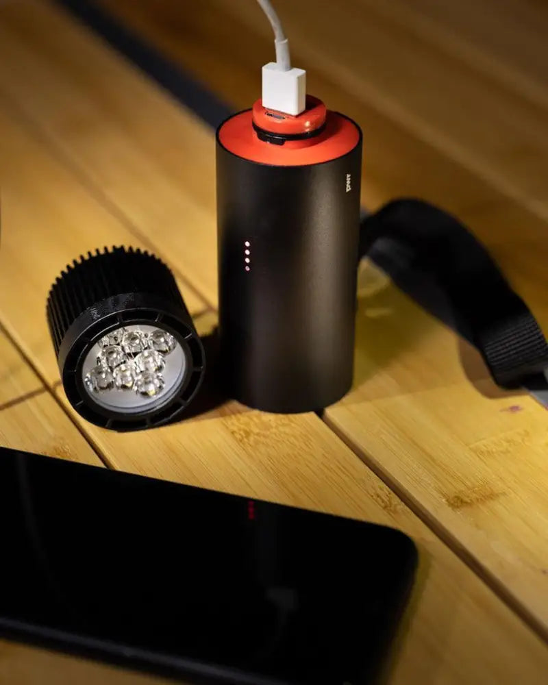 Black cylindrical pwr explorer 2000l portable charger with red top white port matte finish and led indicator lights