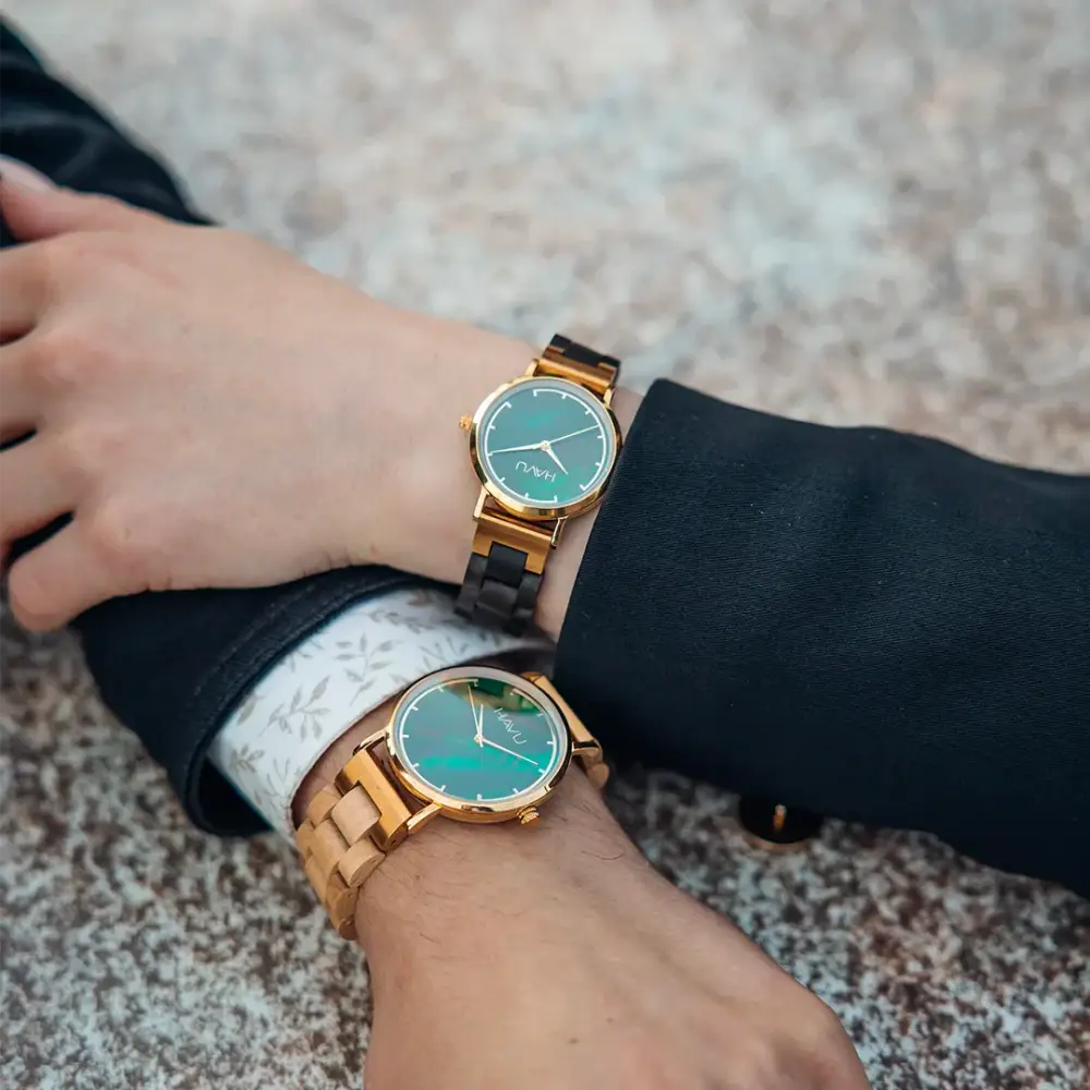 A pair of elegant revontuli eebenpuu wooden watches with gold-tone accents and teal minimalist faces 32mm