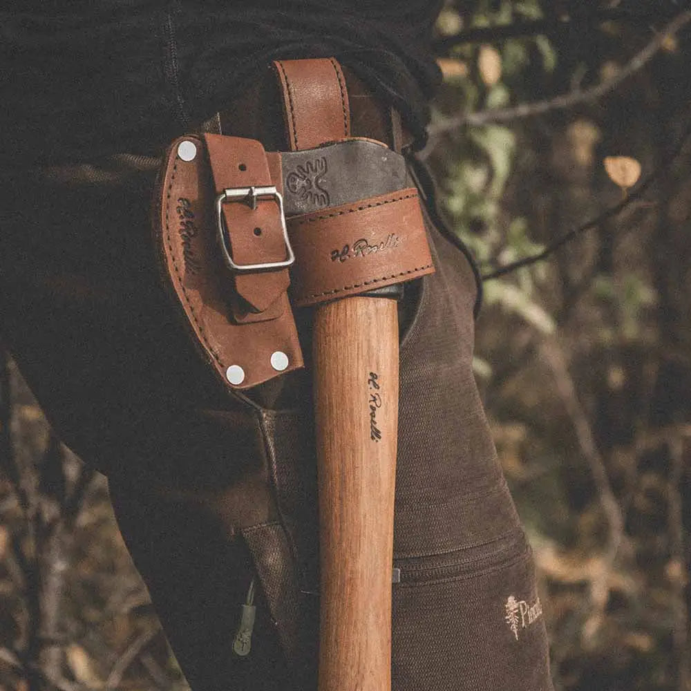 Ruskea nahkainen roselli axes holster hopeisella lukolla ja kohokuvioidulla logolla puisella kahvaisella kirveellä