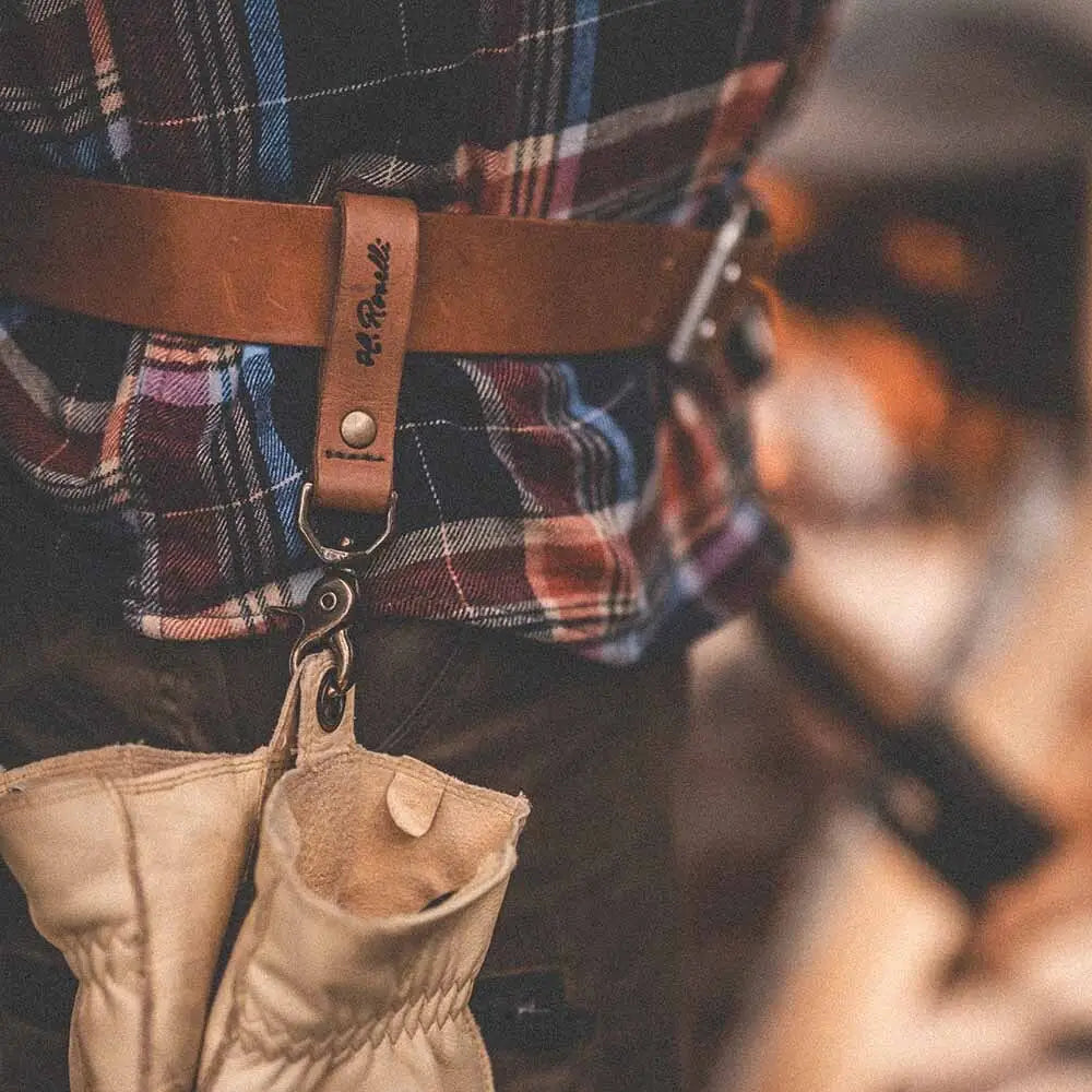 Tan nahkainen roselli belt loop -vyö rip and read -merkillä, jossa metallinen koukku kiinnittää nahkakäsineet