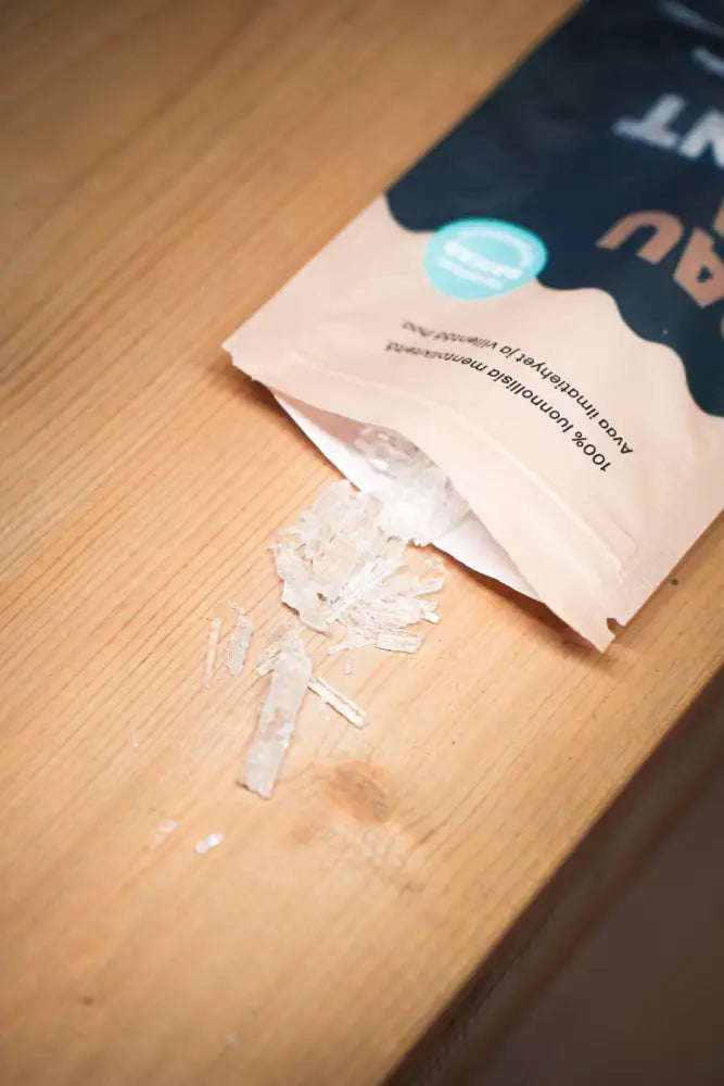 A bag of clear crystalline avocado salt in dark blue and beige packaging labeled sauna menthol original