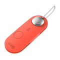 A sleek coral-colored knog smart luggage alarm with a silver button and metallic keychain loop in scout travel red