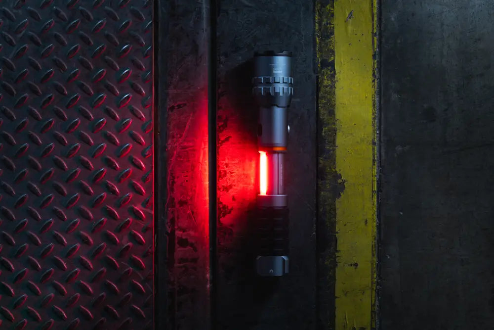 A sleek matte black tactical flashlight slyde king 4k with a red led beam and textured grip
