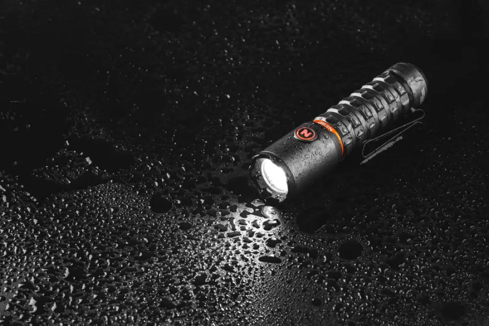 Black tactical flashlight torchy 2k usb c with textured grip and orange accent ring featuring red logo on the side