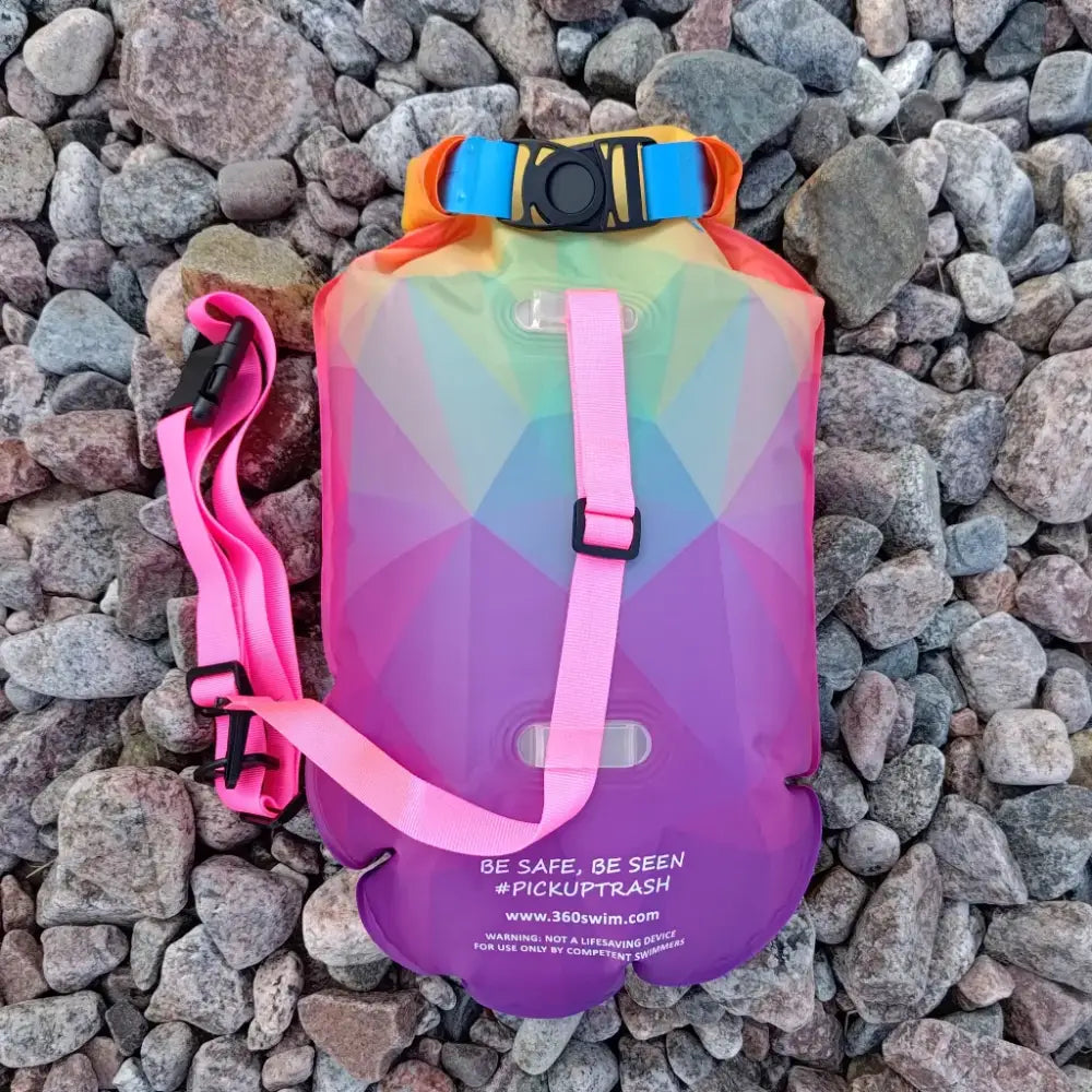 Ultra dazzle drybag on värikäs sateenkaaren värinen vedenpitävä kuivasäkki, jossa on pinkit hihnat ja sininen solki