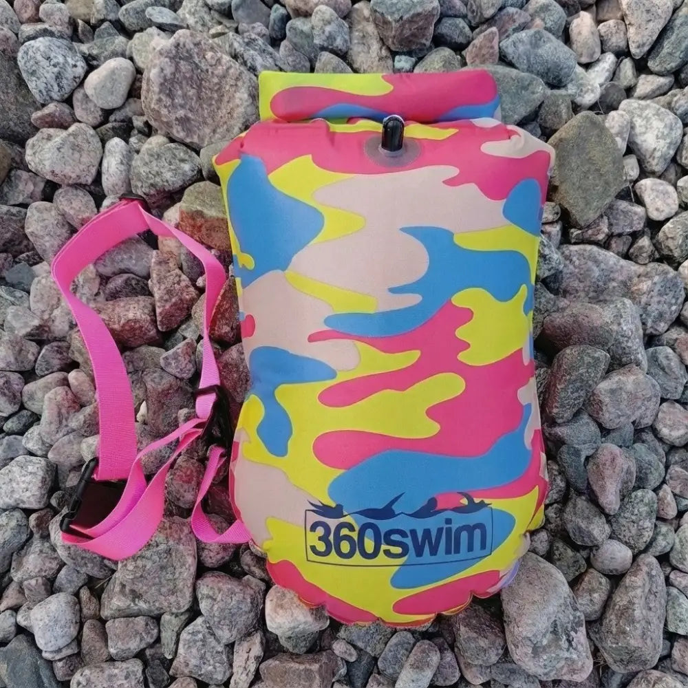 Ultra dazzle drybag buoy on värikäs pinkin, keltaisen ja sinisen maastokuvioitu täytettävä kellukkeet mustalla venttiilillä ja pinkillä hihnalla