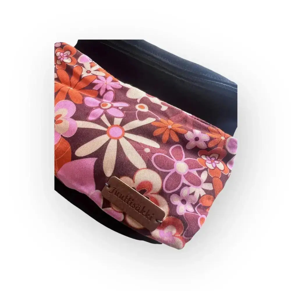 Vibrant floral patterned jumkisakki pouch in pink orange and white on deep brown fabric vyölaukku 70 kotimaista käsityötä