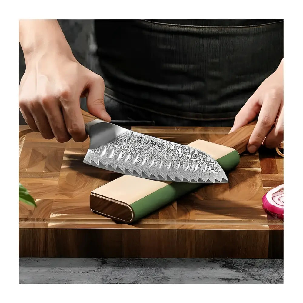 Sleek damascus steel chef knife with wooden handle resting on green and beige stone sharpening block in xinzuo nahkastroppi 2-puolinen set